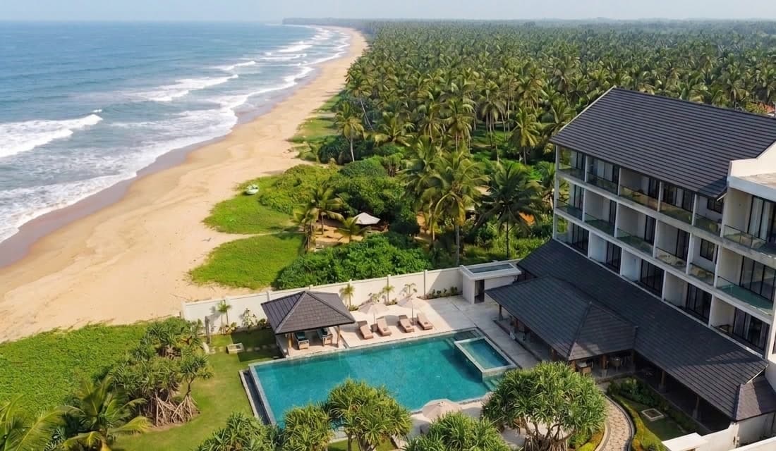 Artist's impression of Beeralu Ceylon from the air: the building and its pool above an open beach running north under coconut palms.